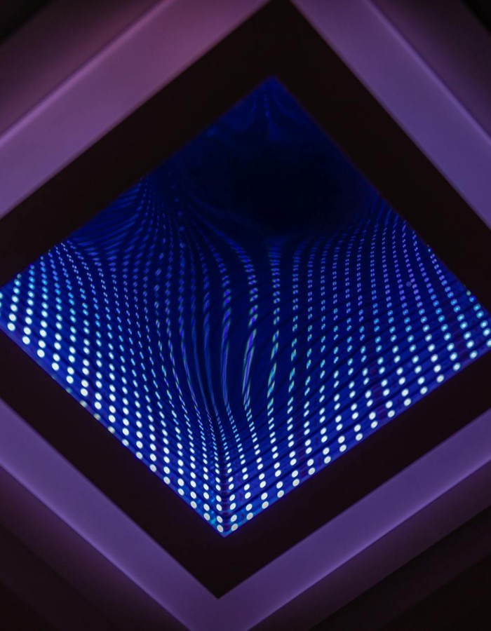 A captivating abstract view of a LED infinity mirror with vibrant light patterns.